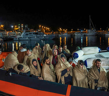 In Decken gehüllte Menschen auf einem Boot