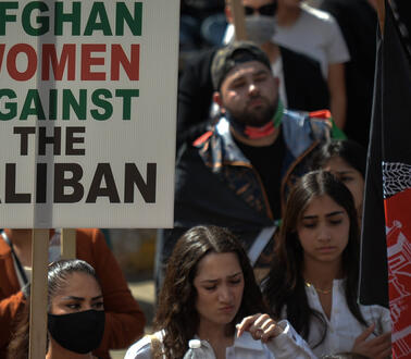 Das Bild zeigt eine Menschenmenge, vor allem Frauen, mit Protestplakaten