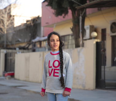 Das Bild zeigt ein Kind mit einem Sweatshirt und der Aufschrift "Love"