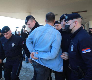 Sicherheitskräfte verhaften einen Mann in blauem Hemd