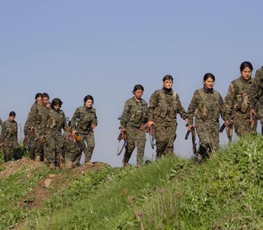 Das Bild zeigt mehrere Frauen in Uniform und mit Waffen