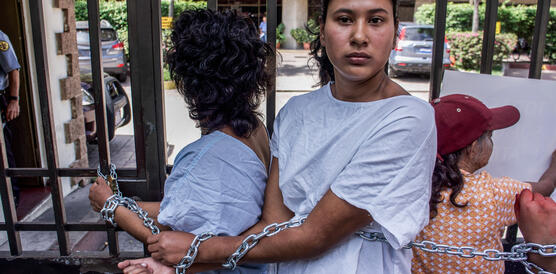 Zwei Frauen protestieren, in dem sie sich selbst an einen Zaun anketten