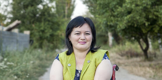 Porträtfoto von Gulzar Diushenova auf einem betonierten Weg zwischen Bäumen