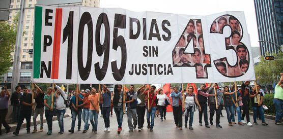 Protestierende halten ein großes Transparent mit den Zahlen 1095 und 43 hoch