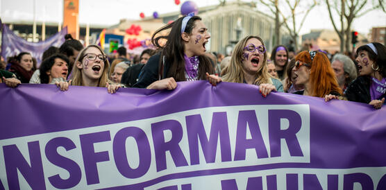 Frauen demonstrieren, singen Slogans, halten ein Plakat