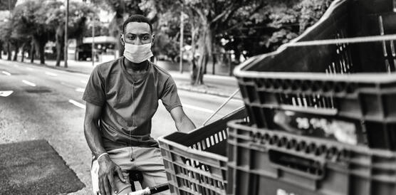 Ein junger Brasilianer, es ist Leandro Amaral, sitzt auf einer Fahrradrikscha, auf der sich Plastikkörbe stapeln.