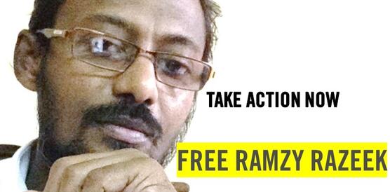 Die Grafik zeigt ein Porträtfoto von Ramzy Razeek. Er trägt eine Brille. Auf der Grafik steht unter anderem: "Free Ramzy Razeek".
