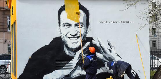 Das Bild zeigt ein Graffiti von Alexej Nawalny, wie es gerade übermalt wird