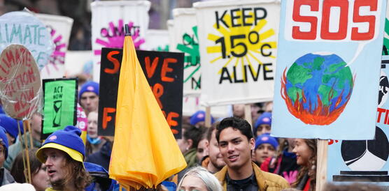Das Bild zeigt eine Demonstration mit vielen jungen Menschen und Schildern mit der Aufschrift "Keep 1.5 C alive"