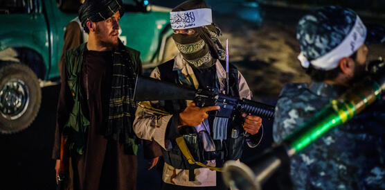 Das Bild zeigt mehrere bewaffnete maskierte Männer