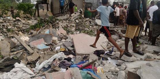 Anwohner_innen der nigerianischen Stadt Port Harcourt stehen in den Trümmern ihrer Häuser