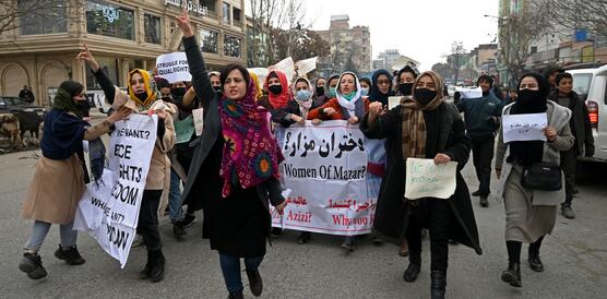 Das Bild zeigte eine Gruppe demonstrierender Frauen mit Bannern und Schildern, die eine Straße entlang laufen.