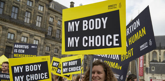 Das Bild zeigt mehrere Demonstrierende auf der Straße mit Schildern wie "My Body My Choice"