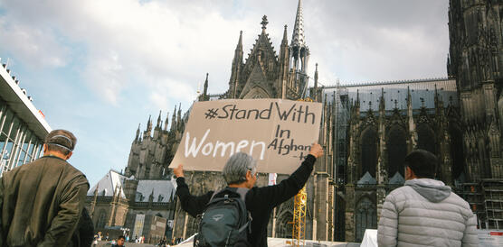 Das Bild zeigt eine Frau mit eine Protestschild