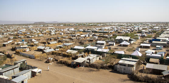 Das Bild zeigt hunderte kleine Hütten, die in einer wüstenähnlichen Landschaft eng nebeinander stehen