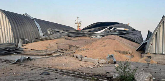 Das Foto zeigt eine zerstörte Halle. Tonnenweise Getreide liegen auf dem Boden und aufgrund der Zerstörung nun unter freiem Himmel.