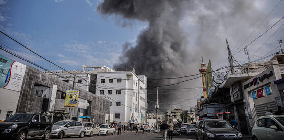 Das Bild zeigt eine große schwarze Rauchwolke, die über Gebäuden einer Stadt austeigt