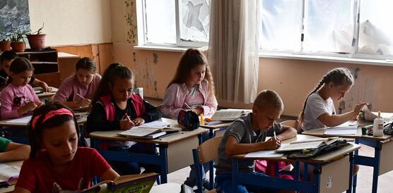 Das Bild zeigt mehrere Schülerinnen und Schüler in einem Klassenzimmer