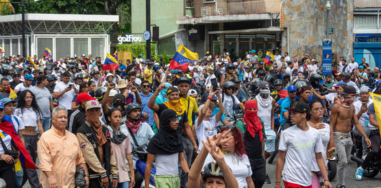 Das Foto zeigt eine Menschenmenge, die demonstrierend durch eine Straße zieht.