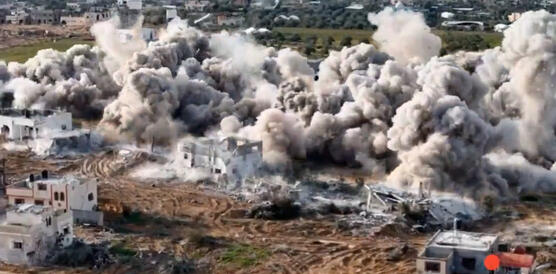 Das Bild zeigt aus der Vogelperspektive eine großflächige Explosion, vermutlich Gebäude, mit viel Staub