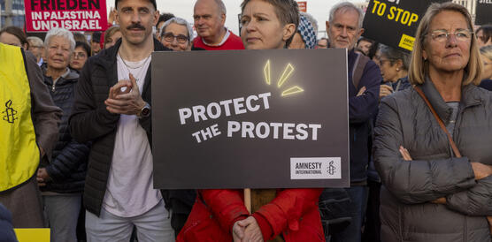 Das Bild zeigt eine Person mit einem Protestplakat