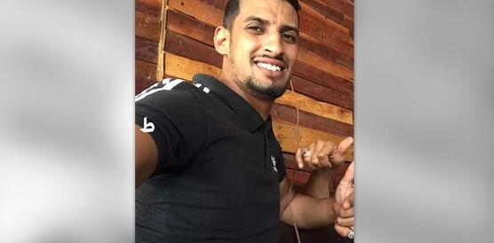 Mann mit schwarzen T-Shirt schaut in die Kamera