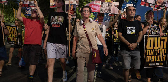 Demonstrierende Menschen mit Schildern und Plakaten.