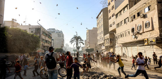 Flugblätter segeln aus der Luft auf Menschen in einer Straße herab.