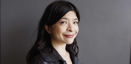 Eine philippinische Frau trägt eine Lederjacke, ihr Haar fällt ihr über die Schultern.