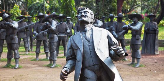Bronzestatuen bilden eine Szene ab, in der ein Mann von anderen Männern erschossen wird.