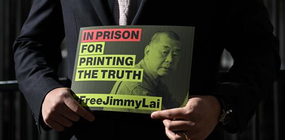 Ein Mann hält ein Plakat mit dem Bild von Jimmy Lai, darauf zu lesen "Free Jimmy Lai"