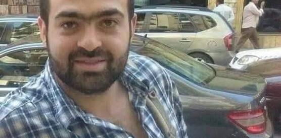 Porträtbild von Mohamed Adel. Er lächelt in die Kamera, hat kurze schwarze Haare