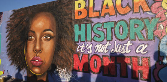 Graffiti einer Schwarzen Frau, daneben der Schriftzug "Black History Month"