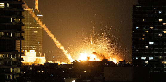 Diese Nachtaufnahme zeigt einen großen Feuerball inmitten von mehreren hohen Gebäuden.