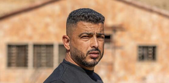 Porträtfoto von Ayman Bani Owda, der ernst in die Kamera blickt.