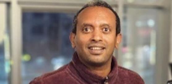 Porträtfoto von Million Beyene, der in die Kamera lächelt.