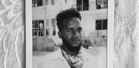 Ein junger Mann aus dem Sudan mit kurzen Haaren auf einer Straße, Polaroidfoto