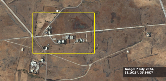 Satellitenbild von Al-Hamidiya vom 7. Juli 2024. Ein gelbes Rechteck markiert intakte zivile Gebäude und Strukturen in einer trockenen, landwirtschaftlich geprägten Landschaft, bevor militärische Aktivitäten stattfanden.