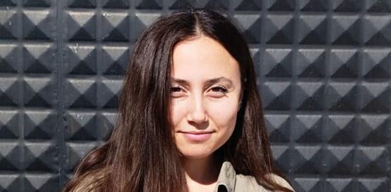 Porträtfoto von Esra Işık. Sie trägt ihr langes Haar offen und lächelt in die Kamera.