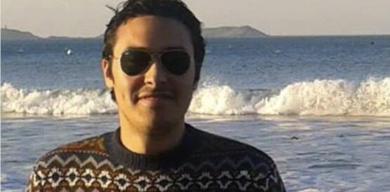 Porträtfoto von Amr Abdelfattah mit dem Meer im Hintergrund. Er trägt eine Sonnenbrille und lächelt in die Kamera.