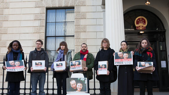 Männer und Frauen halten Schilder hoch