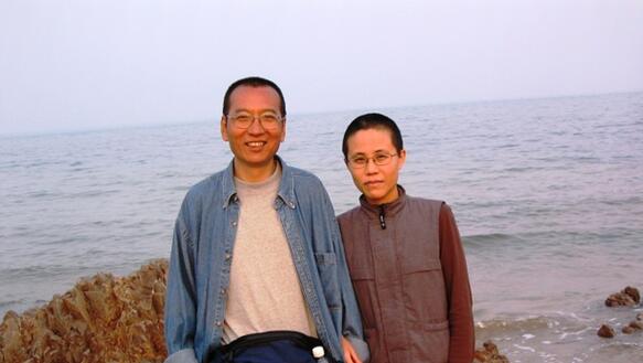 Liu Xiaobo und Liu Xia stehen Arm in Arm am Ufer, im Hintergrund das Meer