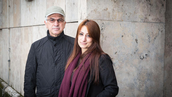 Porträt von Nihad Siris und Widad Nabi vor einer Wand aus Stein