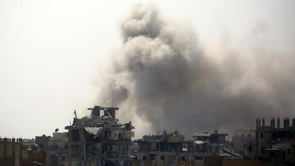 Rauch steigt auf über einem zerstörten Stadteil der syrischen Stadt Rakka