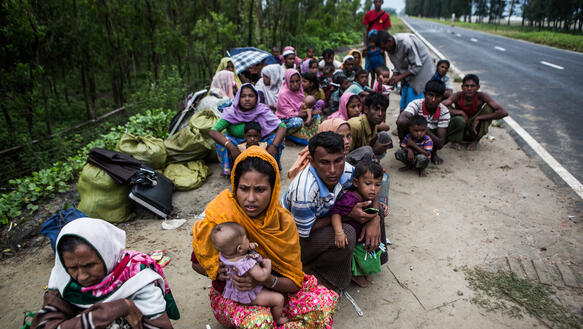 Menschen mit Kindern am Rande einer Straße in Bangladesch