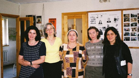 Porträt von fünf Frauen, die nebeneinander in einem Büro stehen