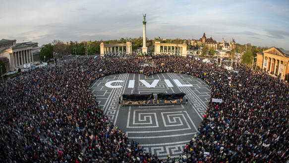 Eine Menschenmenge formt auf einem großen Platz ein Herz, in dem "CIVIL" steht