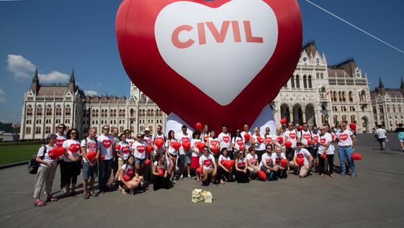 Um die dreißig Personen stehen vor einem riesigen rotenHerzballon auf dem "Civil" geschrieben steht