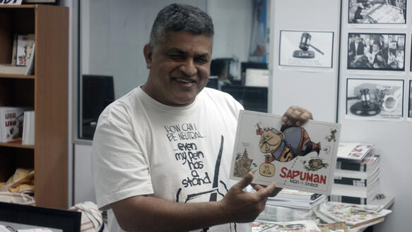 Porträt von Zulkiflee Anwar Ulhaque ("Zunar") mit einer Karikatur in der Hand