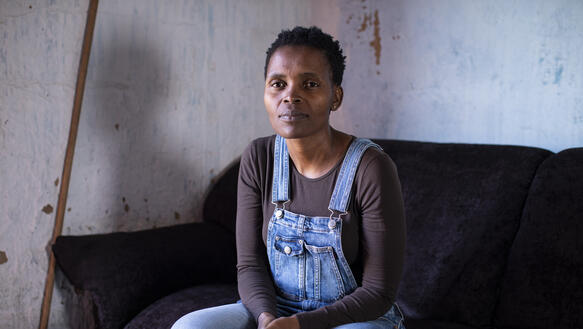 Porträtfoto von Nonhle Mbuthuma auf einem schwarzen Sofa